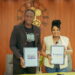 Prince Youlou et Mariame Kangoud debout, présentant fièrement les dossiers officiels signés du partenariat entre Ewawa Plus et L'Archer Fondation à Brazzaville.